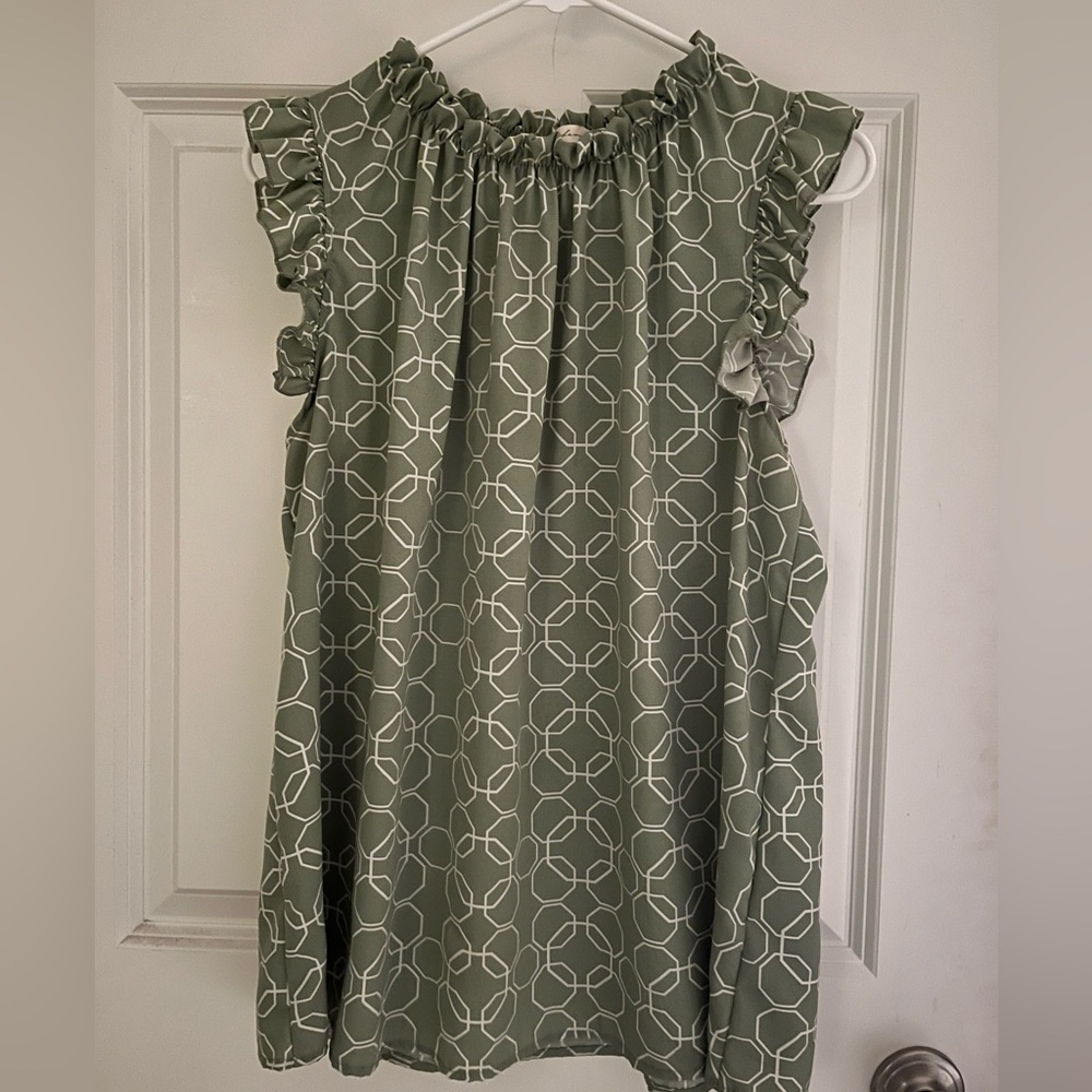 Beautiful ruffle shoulder l, sleeveless top. Fits a bit longer